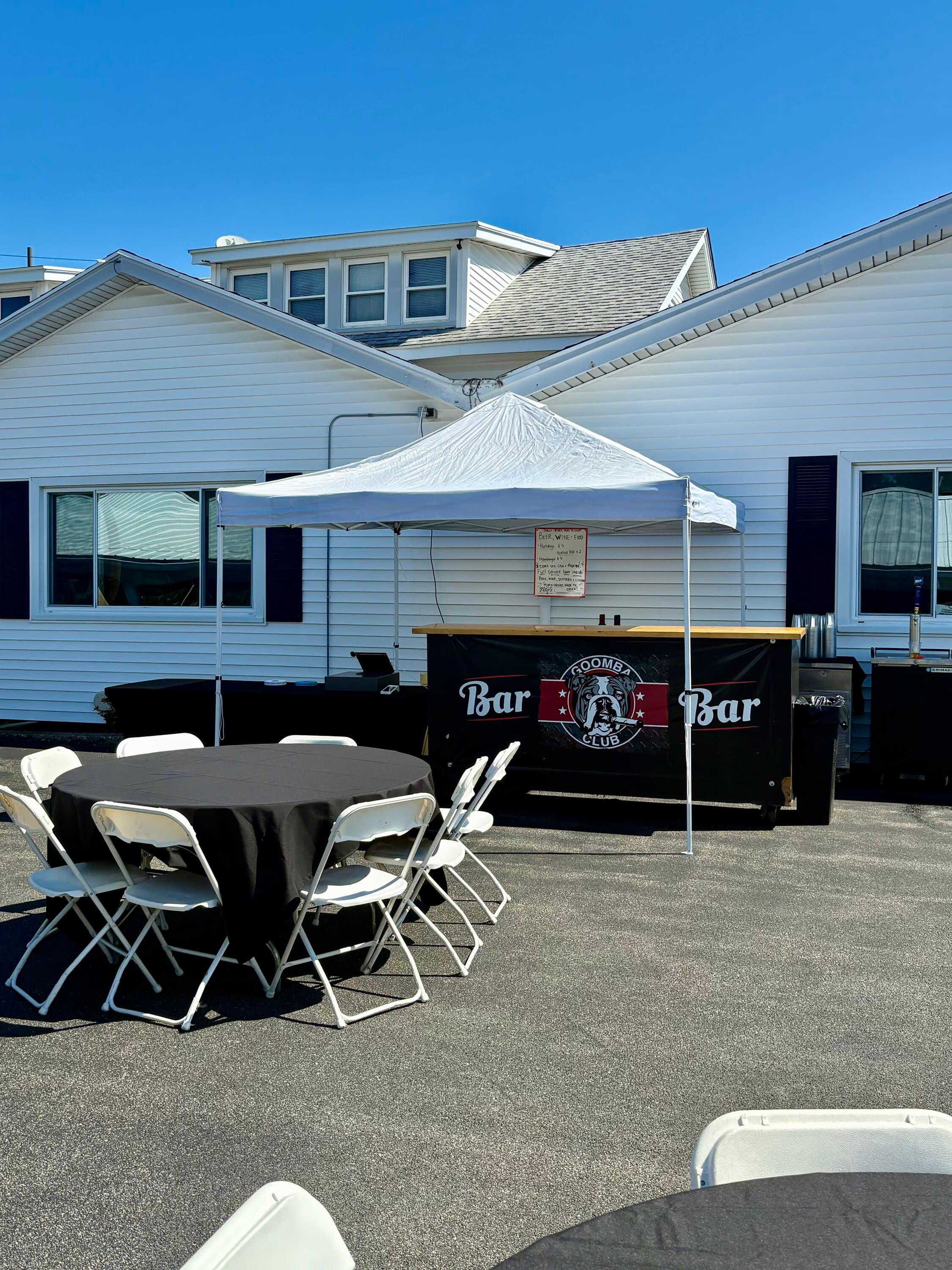 Goomba Club mobile bar setup with white tent and round tables for outdoor event