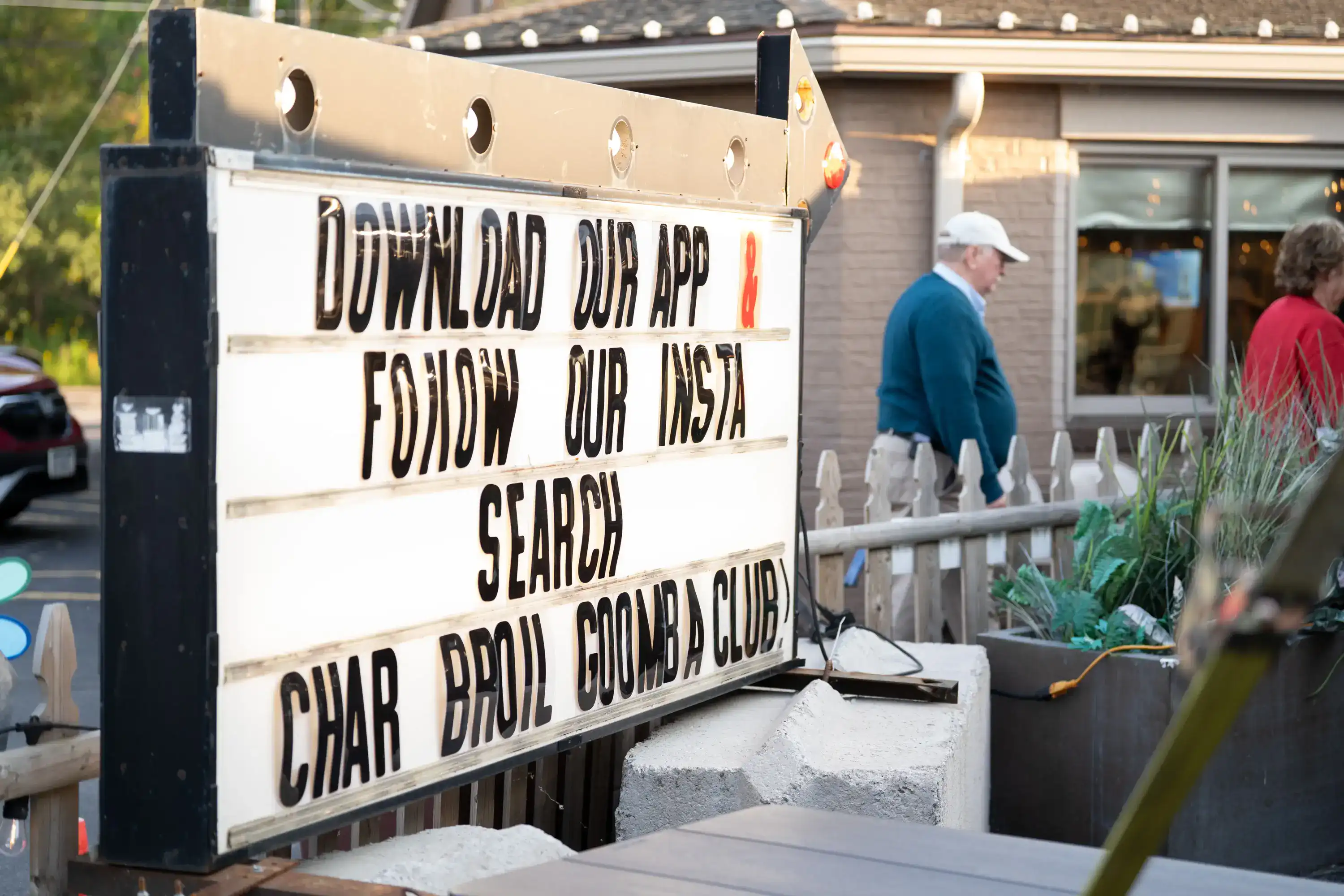Sign reading 'Download our app & follow our insta search char broil goomba club'