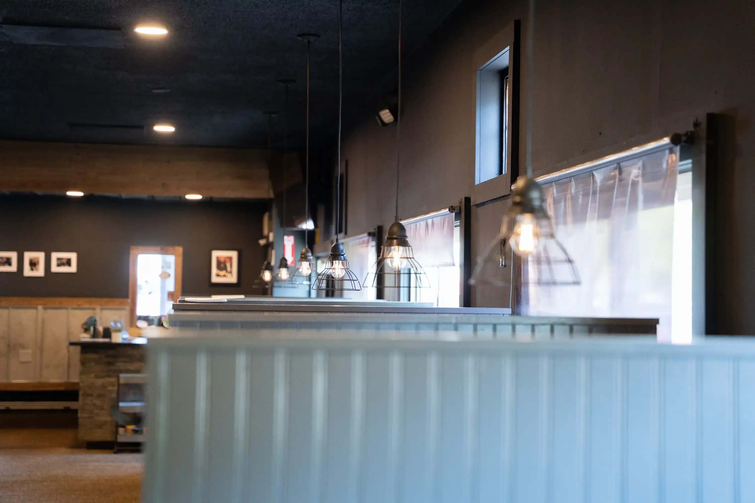 Service counter with wire pendant lights and pass-through window at The Original Charbroil House